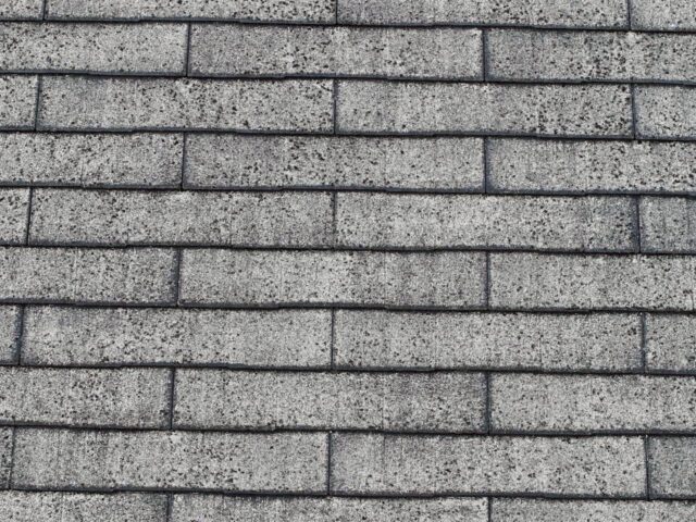 柏原市の築20年戸建てで見られたスレート屋根のひび割れとコケの写真