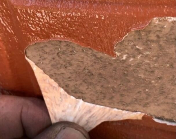 通常の塗料を塗っても表面ではじかれてしまうイメージ、または塗膜が剥がれてしまった他社施工不良の事例写真