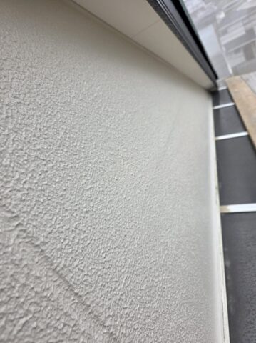 柏原市の現場にて、マスチック工法が完了し、真っ白に肉厚に仕上がった外壁下地の上に、上塗りを行っている最中の写真